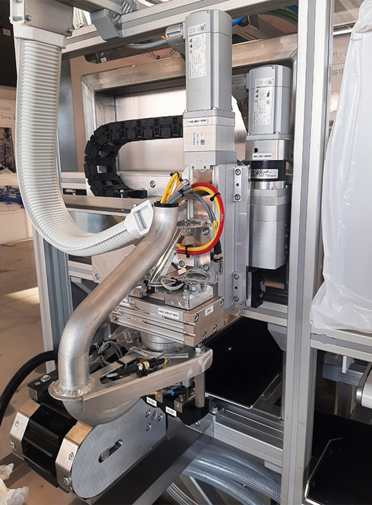 transfer unit with two axes and a swivelling cylinder and prism conveyor for handling medical bottles